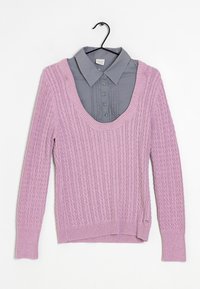 Pull en tricot lilas avec un motif gaufré en torsades, doté d'un large col en forme de scoop. En dessous, une chemise grise à col avec des détails à boutons.