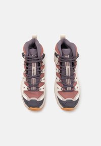 Sportliche Wanderschuhe mit einem Obermaterial aus pinkem und grauem Mesh, weißen Akzenten, grauen Schnürsenkeln, gepolstertem Schaft und einer strukturierten Gummisohle.