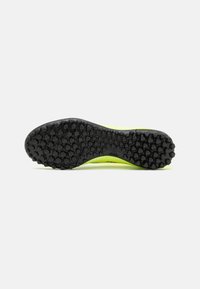 Suola in gomma nera con grip testurizzato, superiore giallo-verde con dettagli di design minimalisti, adatto per uso atletico.