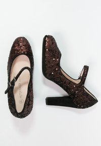 Chaussures à plateformes en sequins bruns avec un bout rond, des accents en suède noir, une sangle avec boucle et un talon épais.