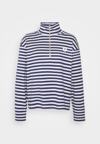 Blå och vitrandig långärmad tröja med hög krage, dragkedjestängning och en liten blomstermonogram på vänster bröst.