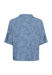 Modra bluzica s kratkimi rokavi, ki ima teksturiran cvetlični vzorec. Brez vidnih gumbov ali zapiranj, z ohlapnim, kvadratnim krojem in ovratnikom.