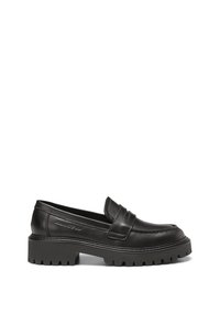 Mocassin en cuir noir avec semelle épaisse à crampons, détails cousus et logo de la marque embossé sur le côté, présenté en vue de profil sur fond blanc.