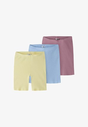 Tre paia di pantaloncini in maglia a coste nei colori giallo pastello, blu e malva, sovrapposti su uno sfondo bianco.