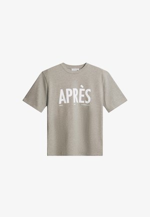 Lichtgrijs T-shirt met korte mouwen en grote witte tekst "APRÈS" met daaronder kleinere teksten "GOLF," "SKI," en "J.LINDEBERG" aan de voorkant.