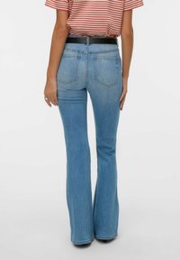 Vaqueros acampanados azul claro hechos de denim, con cintura de tiro medio, diseño de cinco bolsillos y detalles sutiles de costuras en los bolsillos traseros.