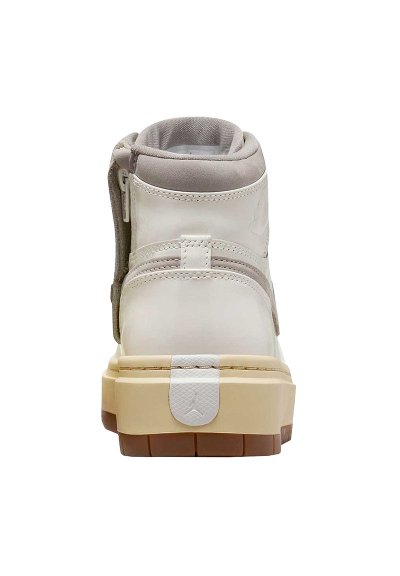 Baskets montantes en cuir blanc avec des accents en daim gris, une semelle beige texturée, une fermeture éclair à l'arrière et un logo blanc au dos.