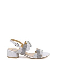 Sandali con tacco argentato e cinturino alla caviglia regolabile, caratterizzati da accenti scintillanti e cinturini a forma di onda in texture argentata e iridescente.