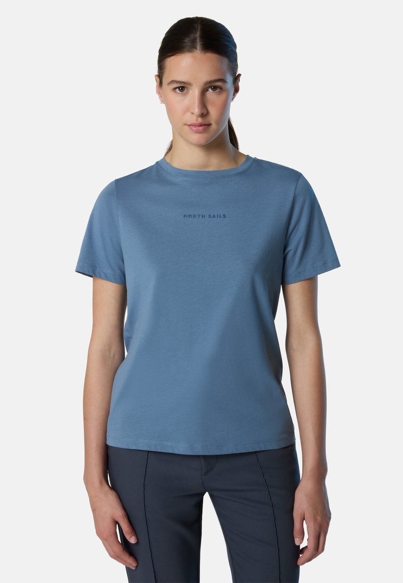 T-shirt blu a maniche corte realizzato in materiale morbido, con colletto a girocollo e logo "NORTH SAILS" stampato in blu scuro. Texture liscia.