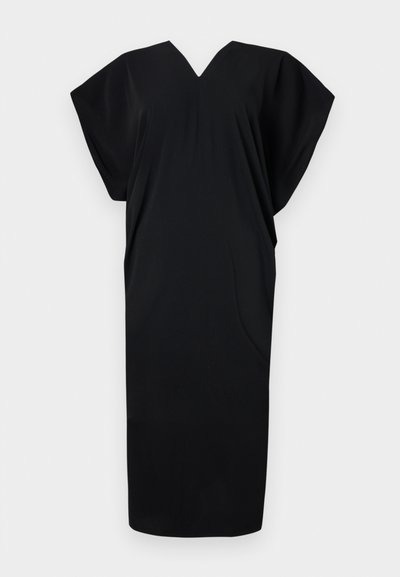 Black dress made of soft fabric, featuring a V-neck, short sleeves, and an oversized, loose fit. Simple design with no visible patterns.