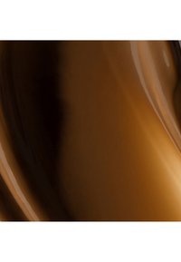 Liquide brun foncé et clair lisse, brillant et tourbillonnant créant une texture riche et fluide.