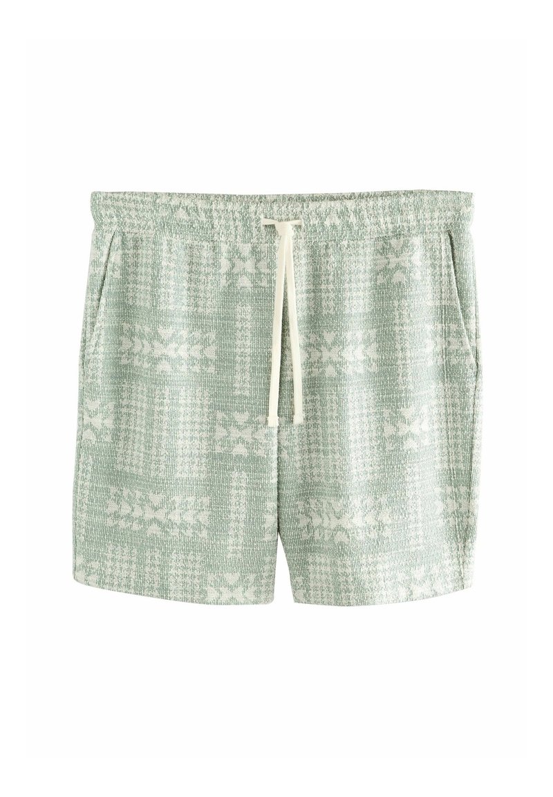 Shorts en maille vert clair avec motifs floraux blancs, taille élastique, cordon blanc et poches latérales.