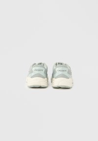 Αθλητικά παπούτσια σε ανοιχτό μπλε και κρεμ χρώμα με επάνω μέρος από υφασμάτινο πλέγμα, επενδεδυμένο γιακά και αντίθετη σόλα· διαθέτουν λογότυπο της μάρκας στη φτέρνα.