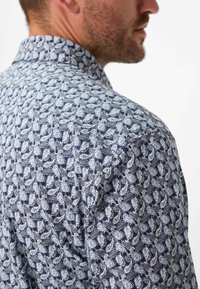 Kurzarmhemd mit navyblauem Grund und einem weißen Paisley-Muster, standardmäßigem Kragen und strukturiertem Stoff.