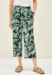 Vzorované široké kalhoty v zelené a černé barvě s listovým potiskem. Vyrobené z lehkého materiálu s elastickým pasem a bočními kapsami.