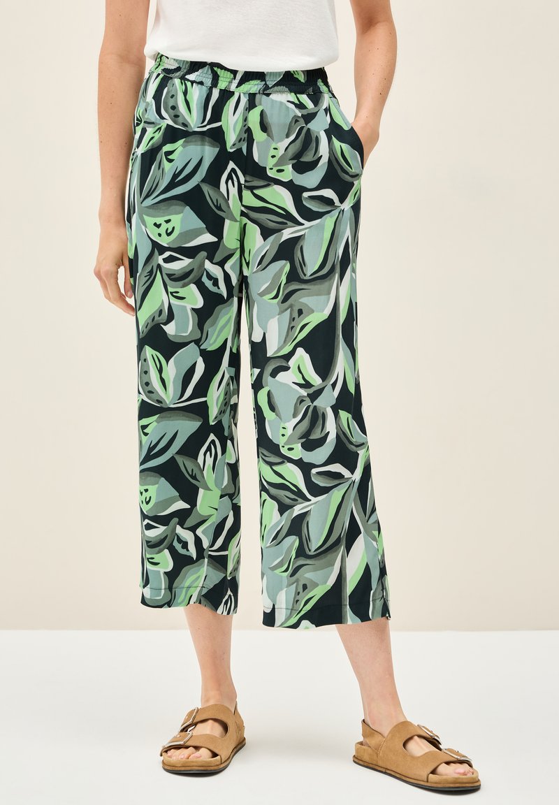 Vzorované široké kalhoty v zelené a černé barvě s listovým potiskem. Vyrobené z lehkého materiálu s elastickým pasem a bočními kapsami.