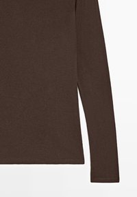 Maglia marrone a costine con maniche lunghe, orlo diritto e spacchi laterali. Presenta un tessuto strutturato con una leggera lucentezza.