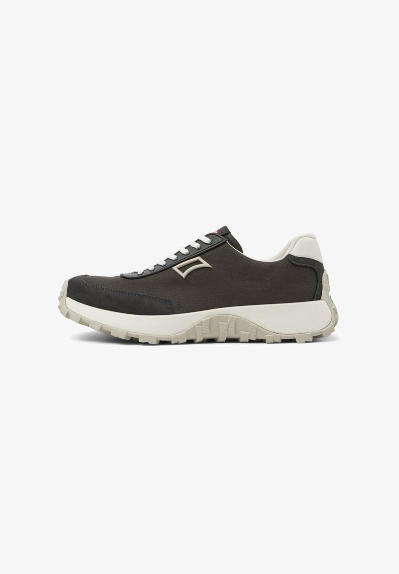 Dark grey sneaker with a textured upper, white accents, a thick sole, and gray laces. Features a minimal logo on the side.