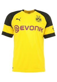 Gul kortärmad fotbollströja med svarta texturerade ärmar. Har 'Evonik'-logotyp i lila och klubbmärke med två stjärnor på bröstet.