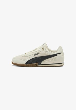 Baskets blanches avec des accents bleu marine, dotées d'une tige en suède, de fermeture à lacets, d'une semelle en caoutchouc naturel et du logo Puma sur le côté et la languette.