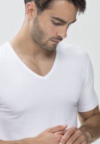 White V-neck T-shirt made of smooth fabric, fitted design, featuring short sleeves and a clean neckline, displayed on a model.