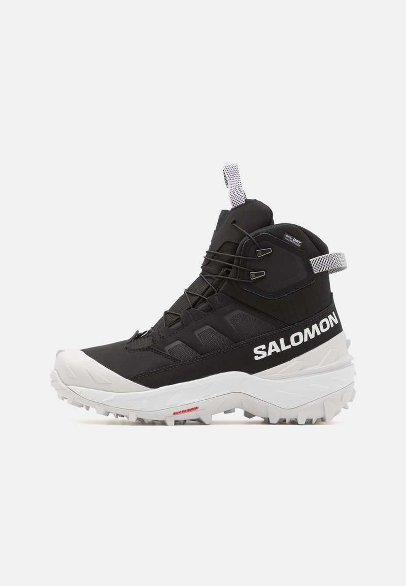 Czarne buty trekkingowe wykonane z materiału syntetycznego, o wysokim kroju, z białą podeszwą i teksturowanymi akcentami, oznaczone napisem "SALOMON."