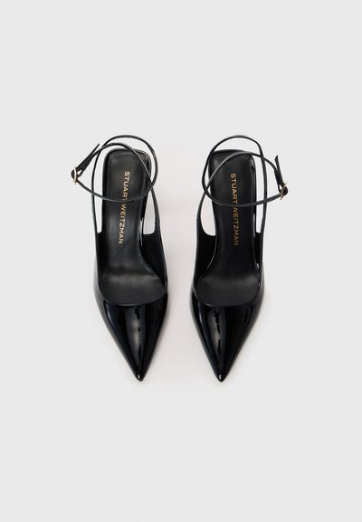 Black patent leather high-heeled shoes with pointed toes, open sides, and thin ankle straps. Gold hardware accents on the straps.