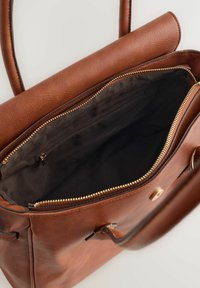 Hnědá kožená kabelka s hladkou texturou, vybavená zapínáním na zip a vnitřní kapsou. Pevné, dlouhé rukojeti s minimálním kováním.