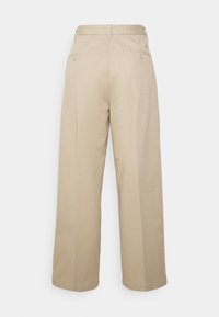 Beige weite Baumwollhosen mit glatter Textur. Sie verfügen über eine hohe Taille, Gesäßtaschen und einen geraden Schnitt, der eine lockere Passform bietet.