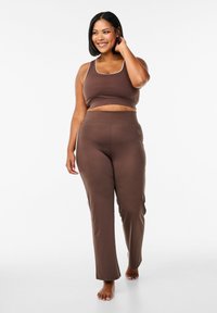 Brown athletic crop top and matching pants made of smooth material, featuring a simplistic design with a white trim along neckline.