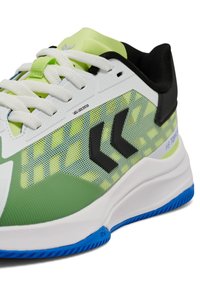 Groene en witte sportieve schoen met een textuur van mesh aan de bovenkant, zwarte accenten en een blauwe zool. Beschikt over een veterslot-systeem en een geometrisch patroon.