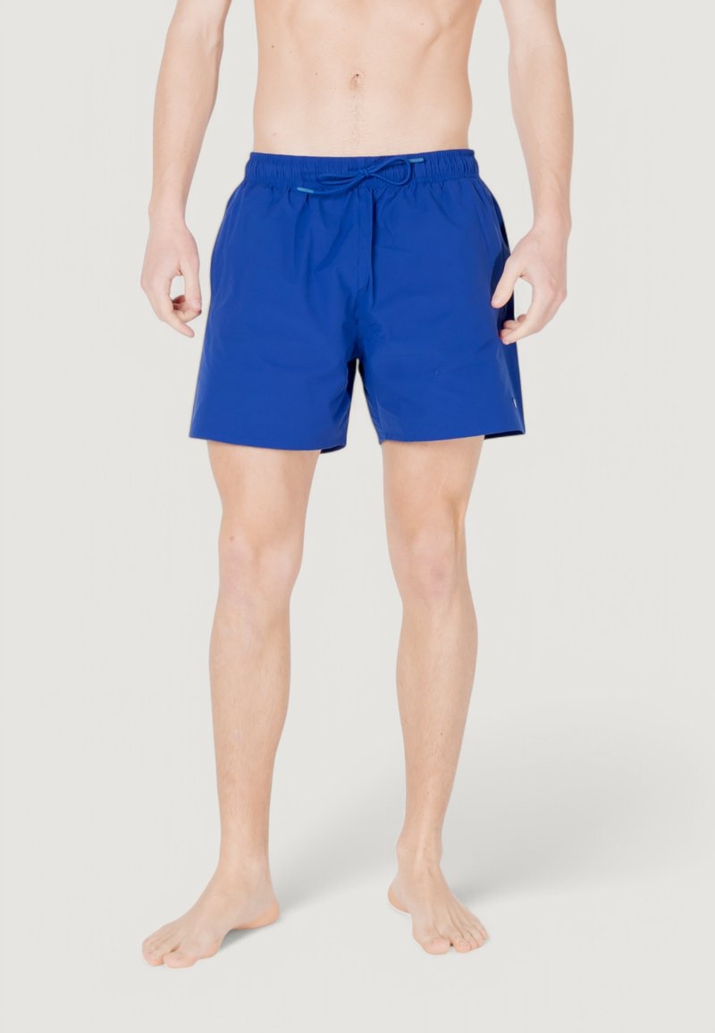 Bañador azul con cintura elástica y cordón, con una textura suave y una longitud por encima de la rodilla.