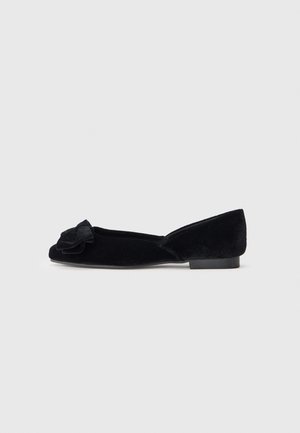 Scarpe flat da donna in velluto nero con un piccolo tacco e un fiocco decorativo sulla punta, mostrate di lato su uno sfondo semplice.