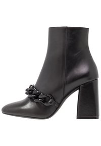 Botines de cuero negro hasta el tobillo con punta afilada, tacón cuadrado y un acento de cadena alrededor del tobillo. Textura suave y diseño elegante.