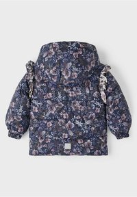Blumige Pufferjacke in Dunkelblau, mit lebendigen lila und rosa Blumen. Gefranste Akzente an den Ärmeln und elastische Bündchen.