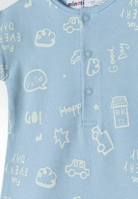 Svijetloplava kratkosuknja onesie s bijelim razigranim grafika, uključujući automobile, oblake i govorničke balone, s dugmadima za kopčanje na vratu.