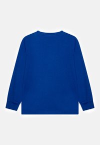 Camisa de algodón azul de manga larga con cuello redondo, textura suave y puños de punto. Diseño sencillo sin patrones visibles ni adornos.