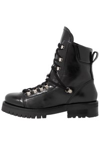 Bottine en cuir noir avec un bout arrondi, un laçage à l'avant, des œillets en métal et une semelle crantée épaisse pour une bonne traction.