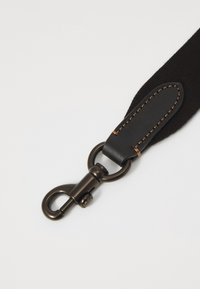 Sort rem med læderdetaljer, prydet med dekorativ syning og en metalspænde. Glat tekstur med en mat finish.