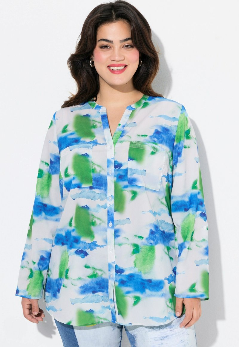 Blusa a maniche lunghe in tessuto leggero e trasparente con un motivo ad acquerello nei toni del blu e del verde. Presenta una chiusura frontale con bottoni e due tasche sul petto.