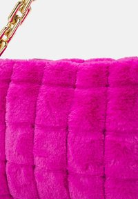 Borsa in finta pelliccia di un vivace rosa con texture morbida, caratterizzata da un design trapuntato e una tracolla in catena dorata come accent decorativo.