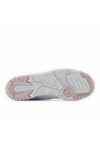 Vit och ljusrosa sportingtssula med mönstrad slitbana, som har texten "new balance" och en texturerad yta för grepp.