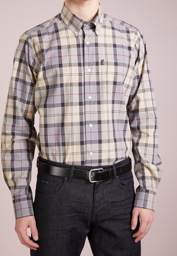 Knoopshirt van katoen in beige met een grijs en donkerrood ruitpatroon; heeft een kraag en knopenmanchetten, gecombineerd met donkere spijkerbroeken en een zwarte riem.