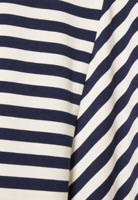 Tkanina bawełniana w paski, z naprzemiennymi poziomymi paskami w kolorze granatowym i kremowym. Tekstura wydaje się gładka i miękka, idealna do codziennego noszenia.