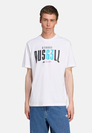 White cotton t-shirt featuring black and teal graphic text "GEORGE RUS63LL." Finished with a crew neck and short sleeves, paired with blue denim jeans.