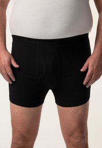 Boxer shorts neri in cotone con elastico in vita, caratterizzati da un logo discreto. Progettati per il comfort, con una vestibilità standard e gambe di lunghezza media.