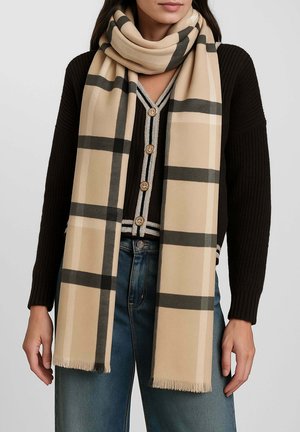 Sciarpa a quadri beige realizzata in tessuto morbido, caratterizzata da linee nere e grigie con bordi sfrangiati, drappeggiata su un maglione scuro.