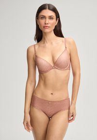 Completo di lingerie rosa chiaro composto da un reggiseno senza ferretto con pizzo e da una mutandina a vita bassa coordinata, entrambi con motivi floreali e finitura in raso.