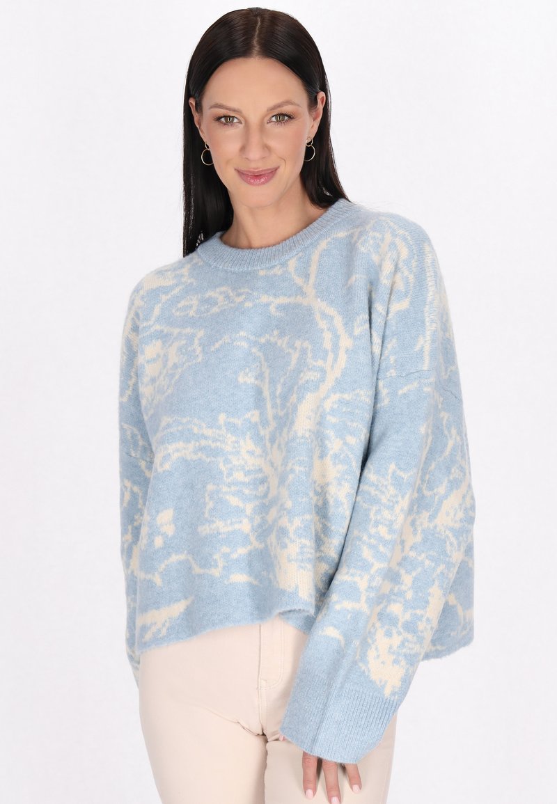 Pulover de culoare albastru deschis cu un model abstract crem, textură moale, manșete cu nervuri și croială relaxată. Potrivit pentru ținute casual.