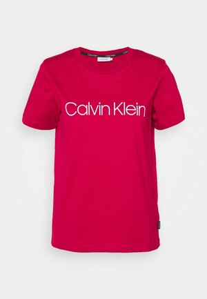 T-shirt rouge vif à manches courtes avec le logo blanc "Calvin Klein" centré sur le devant et une étiquette noire de la marque sur la couture latérale.